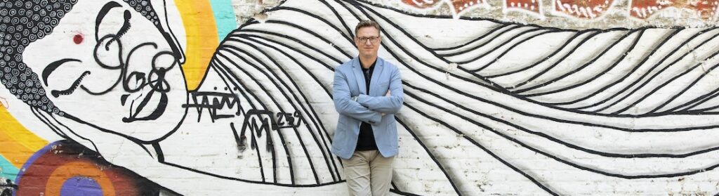 Mann vor großem abstrakten Wandgemälde